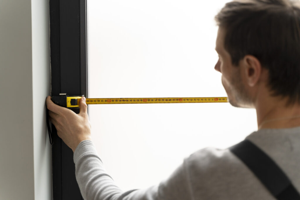 a man measuring the available space to buy new furniture that fits
