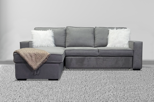 A sleeper sectional sofa in a dual-use home office guest room
